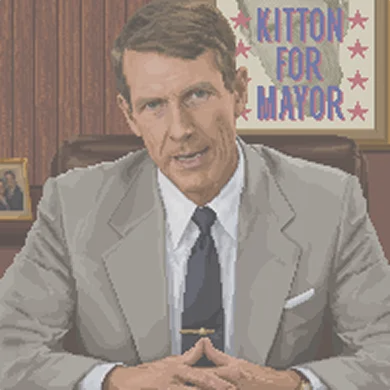 Mayor Dick Kitton at his desk, in front of a Kitton for Mayor poster